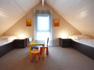 a room with a table and chairs in a attic at Ferienhaus Ostseeblick 236 in Baabe