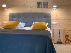 1 dormitorio con 1 cama grande con almohadas amarillas en Dom Wysoki, en Bukowina Tatrzańska