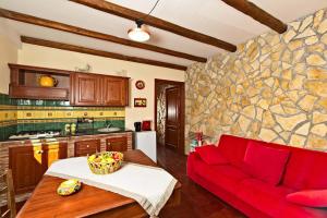 a living room with a red couch and a stone wall at HORSE HOUSE in Ragalna
