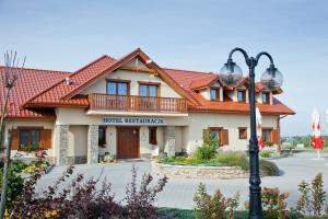 a house with a red roof and a street light at Hotel Bonsai in Niemcza