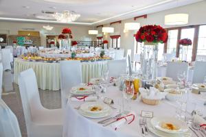 a banquet hall with white tables and white chairs at Hotel Bonsai in Niemcza