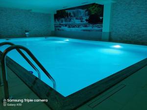 a swimming pool with blue lighting in a room at Hotel Rekic in Bihać