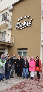 un grupo de personas de pie frente a un hotel en Hotel Rekic, en Bihać