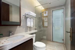 y baño con aseo, lavabo y ducha. en Iccssi Villa Haitang Bay Sanya en Sanya