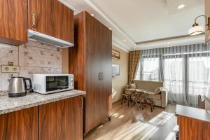 a kitchen with a microwave and a living room at OASIS SUITES OLD CITY in Istanbul