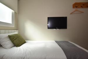a bedroom with a bed with a flat screen tv on the wall at Hotel QB Dongdaemun Gallery in Seoul +28 photos