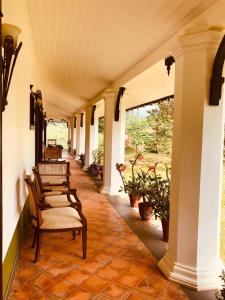 a porch with a row of chairs and plants at Parisons Plantation Experiences by Abad in Mananthavady