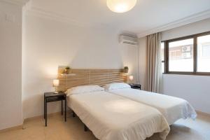 マラガにあるApartamento Soho Málagaの白いベッドルーム(大型ベッド1台、窓付)