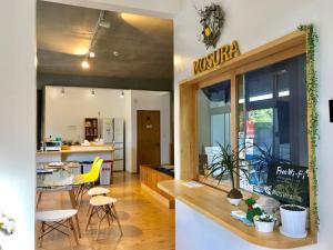 a kitchen and dining room with a table and chairs at Hostel Mosura no Tamago in Motobu