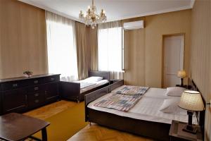 sypialnia z 2 łóżkami i żyrandolem w obiekcie Tinikos Guest House w mieście Telawi