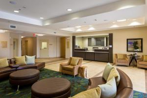 um átrio do hotel com sofás e cadeiras e uma cozinha em Candlewood Suites San Marcos, an IHG Hotel em San Marcos
