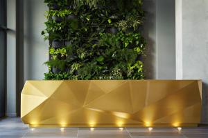 a gold bench in front of a green wall at Kimpton Sawyer Hotel, an IHG Hotel in Sacramento