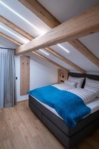 a bedroom with a large bed with a blue blanket at Apartment Haus Schönwies in Alpbach