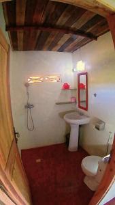 a small bathroom with a toilet and a sink at LES CHALETS DE MELINDA in Nosy Be