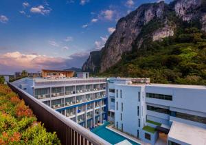 a hotel with a mountain in the background at BlueSotel SMART Krabi Aonang Beach - Adults only in Ao Nang Beach