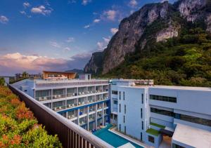 un hotel con una montagna sullo sfondo di BlueSotel SMART Krabi Aonang Beach - Adults only - SHA Extra Plus ad Aonang Beach