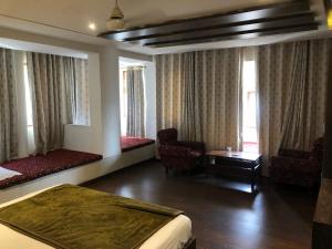 Cette chambre d'hôtel comprend deux lits, une table et des chaises. dans l'établissement Hotel Rani Palace, à Udaipur