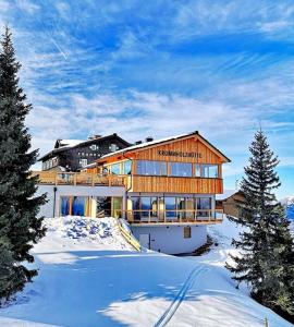 ein Haus auf einem schneebedeckten Berg in der Unterkunft Krummholzhütte in Haus im Ennstal