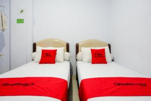 A bed or beds in a room at RedDoorz @ Hotel Bravo Pantai Kamali Bau Bau
