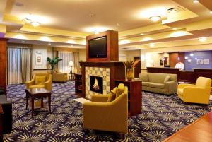 Ridge ManorにあるHoliday Inn Express Hotel & Suites Brooksville-I-75, an IHG Hotelの暖炉とテレビ付きのホテルロビー