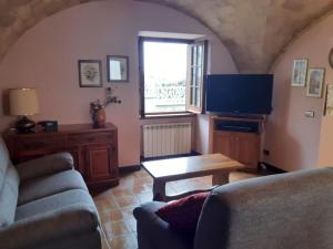 sala de estar con sofá, mesa y TV en CASCINA NELLA CAMPAGNA ABRUZZESE, en Isola del Gran Sasso dʼItalia