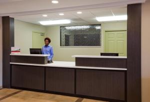 a woman standing at a reception desk in an office at Candlewood Suites Dickinson, an IHG Hotel in Dickinson