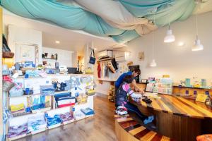 a woman and a child at a counter in a store at Cyclo No Ie in Imabari