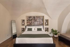 a bedroom with a large bed with a painting on the wall at Le Pennellate Short Lets in Catania