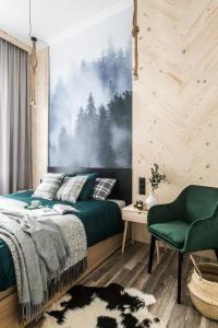 a bedroom with a green bed and a green chair at Black River Apartment in Czarny Dunajec