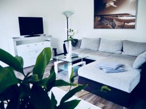 a living room with a couch and a table at CasaSmart // Das Ferienhaus am Harz Nordhausen in Nordhausen