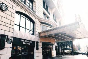 a building with a starbucks coffee shop on a street at Grand Noble Hotel Dongguan in Dongguan