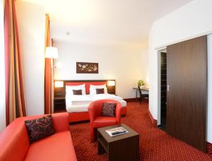 a hotel room with a bed and a couch at Best Western Plus Amedia Wien in Vienna