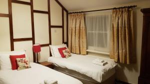 two twin beds in a room with a window at The Wheatsheaf Inn in Ludlow