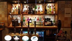a bar with a lot of bottles of alcohol at The Wheatsheaf Inn in Ludlow +13 photos
