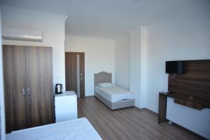 a bedroom with a bed and a television in it at Yeşilyurt Residence in Izmir