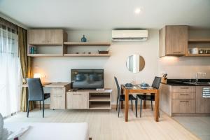 a kitchen and dining room with a table and a television at Apartments at The Bliss Condo by Lofty in Patong Beach