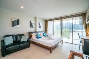 a bedroom with a bed and a black leather couch at Apartments at The Bliss Condo by Lofty in Patong Beach