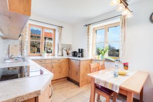 uma cozinha com armários de madeira e uma mesa com cadeiras em Ferienwohnung Bergblick em Bad Heilbrunn