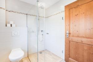 a bathroom with a shower with a toilet and a glass door at Ferienwohnung Bergblick in Bad Heilbrunn +13 photos
