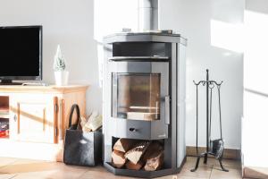 a wood burning stove in a living room at Ferienwohnung Bergblick in Bad Heilbrunn