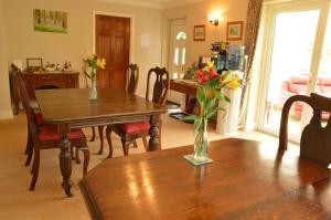 un comedor con dos mesas y una mesa con flores. en Bryn Hebog, en Carmarthen