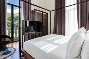 a bedroom with a bed with a tv and a window at One Shot Tabakalera House in Donostia-San Sebastián