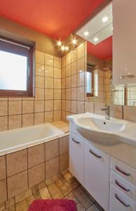 a bathroom with a tub and a sink and a tub and a mirror at Appartement White Chili in Saalbach Hinterglemm