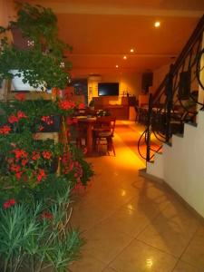 a room with flowers and a dining room with a table at Motel Ioanis in Mîndruloc