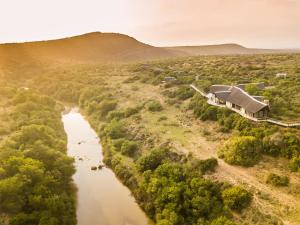 an aerial view of a river with a house at Kwandwe Great Fish River Lodge in Grahamstown