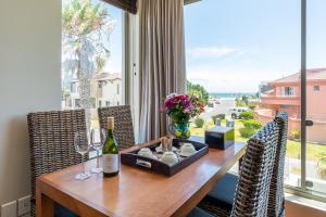 una mesa de comedor con copas de vino y una ventana en da Heim Guest House, en Ciudad del Cabo
