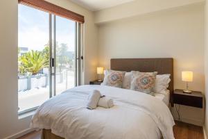 Un dormitorio con una cama grande con una ventana grande. en da Heim Guest House, en Ciudad del Cabo 149 fotos más