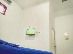 1 dormitorio con 1 cama y TV en la pared en Wisma Aira en Ternate