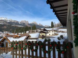 a fence covered in snow with flowers on it at Villa Ombretta in Soraga +10 photos