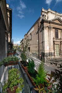 a balcony with potted plants on a city street at Santa Caterina da Siena B&B in Catania